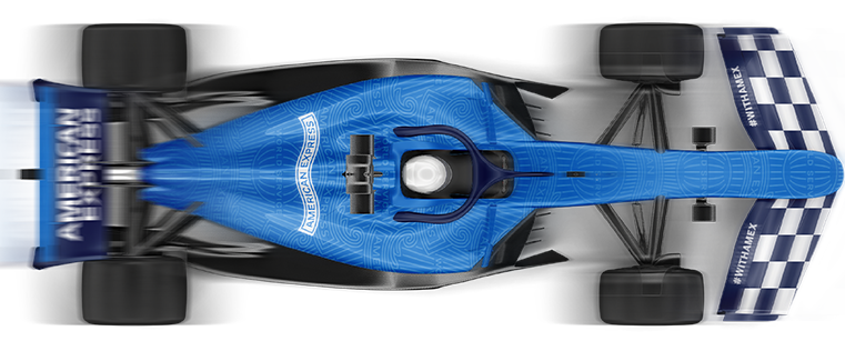 Top-down view of a Formula 1 race car in blue and black, featuring the American Express logo on the rear wing and body. The car includes a blue pattern and a chequered flag design at the rear, with the hashtag #WITHAMEX visible on the front wing. The blurred wheels create a sense of motion.